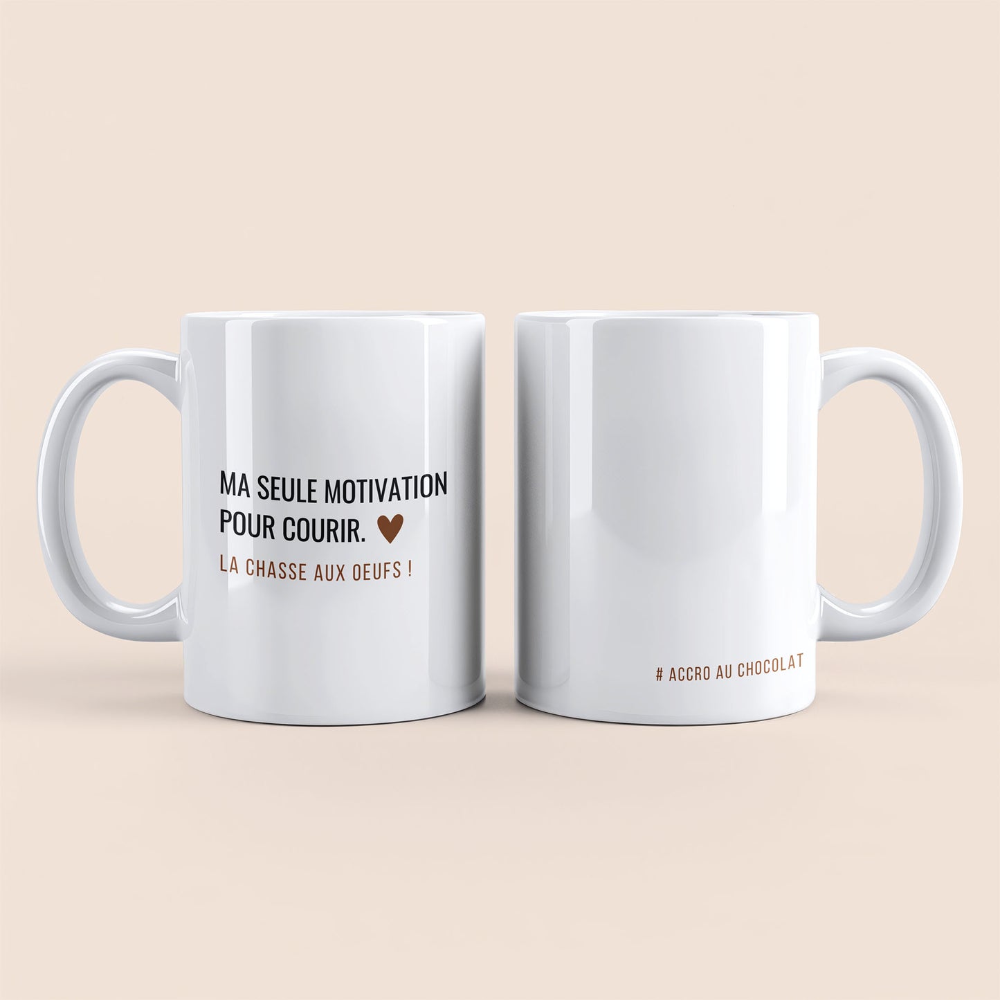 Mug blanc. Texte "# accro au chocolat" à droite. Texte "Ma seule motivation pour courir. La chasse aux œufs !" et un cœur marron à gauche.