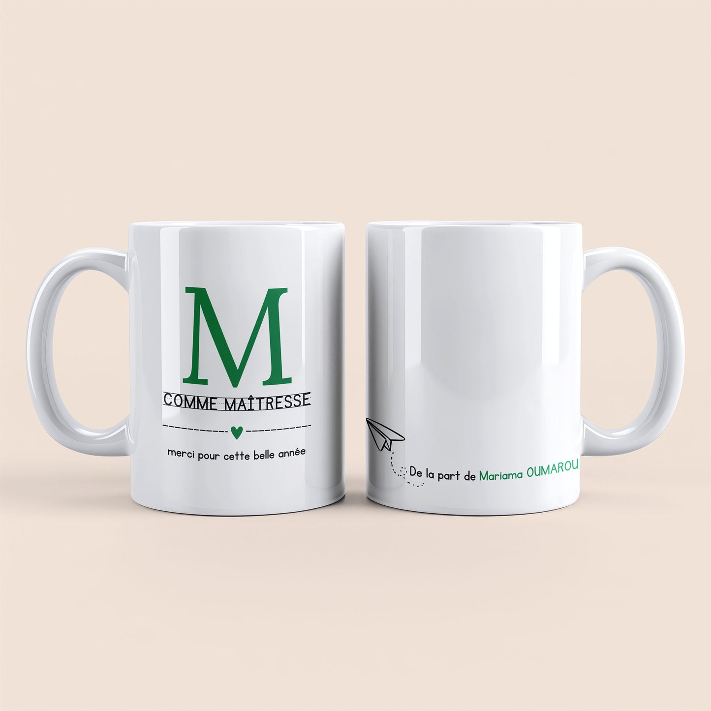 Mug blanc. Lettre M (maîtresse) et un cœur vert plus texte à gauche. Texte personnalisé avec nom à droite.