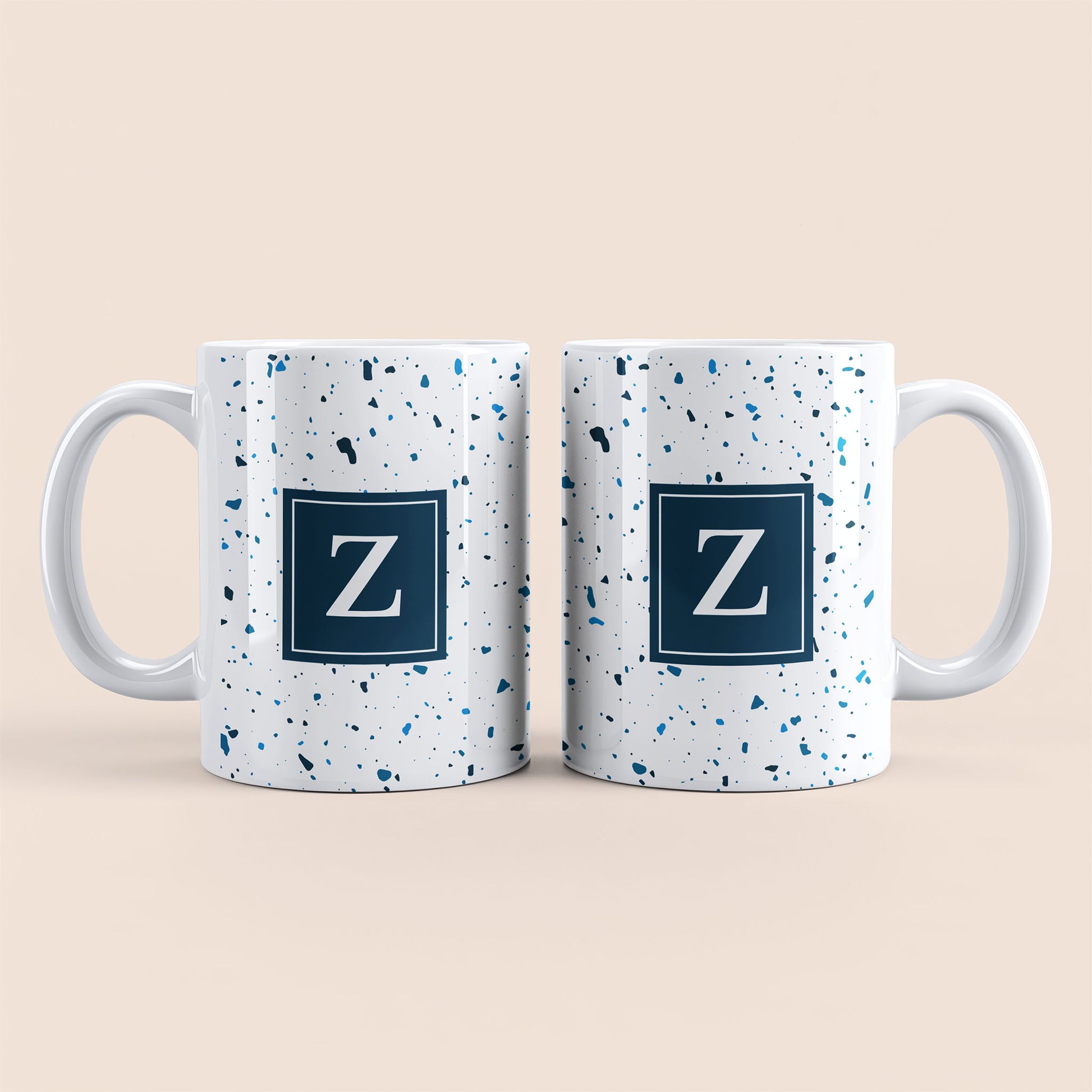 Mug blanc lettre personnalisé. Moucheté et avec un carré bleu au centre.