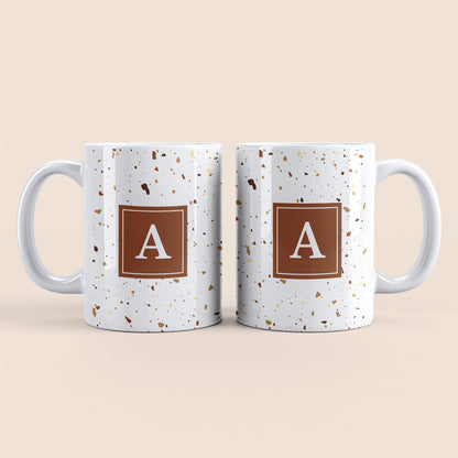 Mug blanc lettre personnalisé. Moucheté et avec un carré marron au centre.