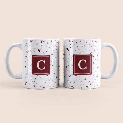 Mug blanc lettre personnalisé. Moucheté et avec un carré rouge au centre.