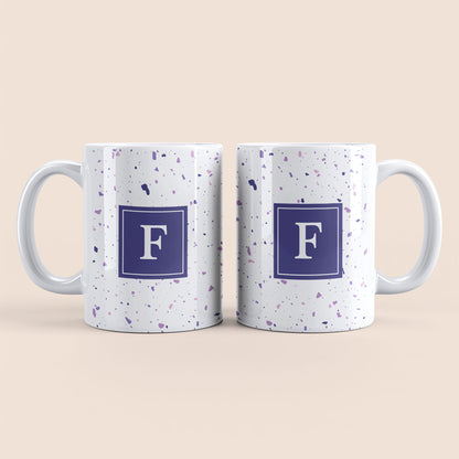 Mug blanc lettre personnalisé. Moucheté et avec un carré violet au centre.