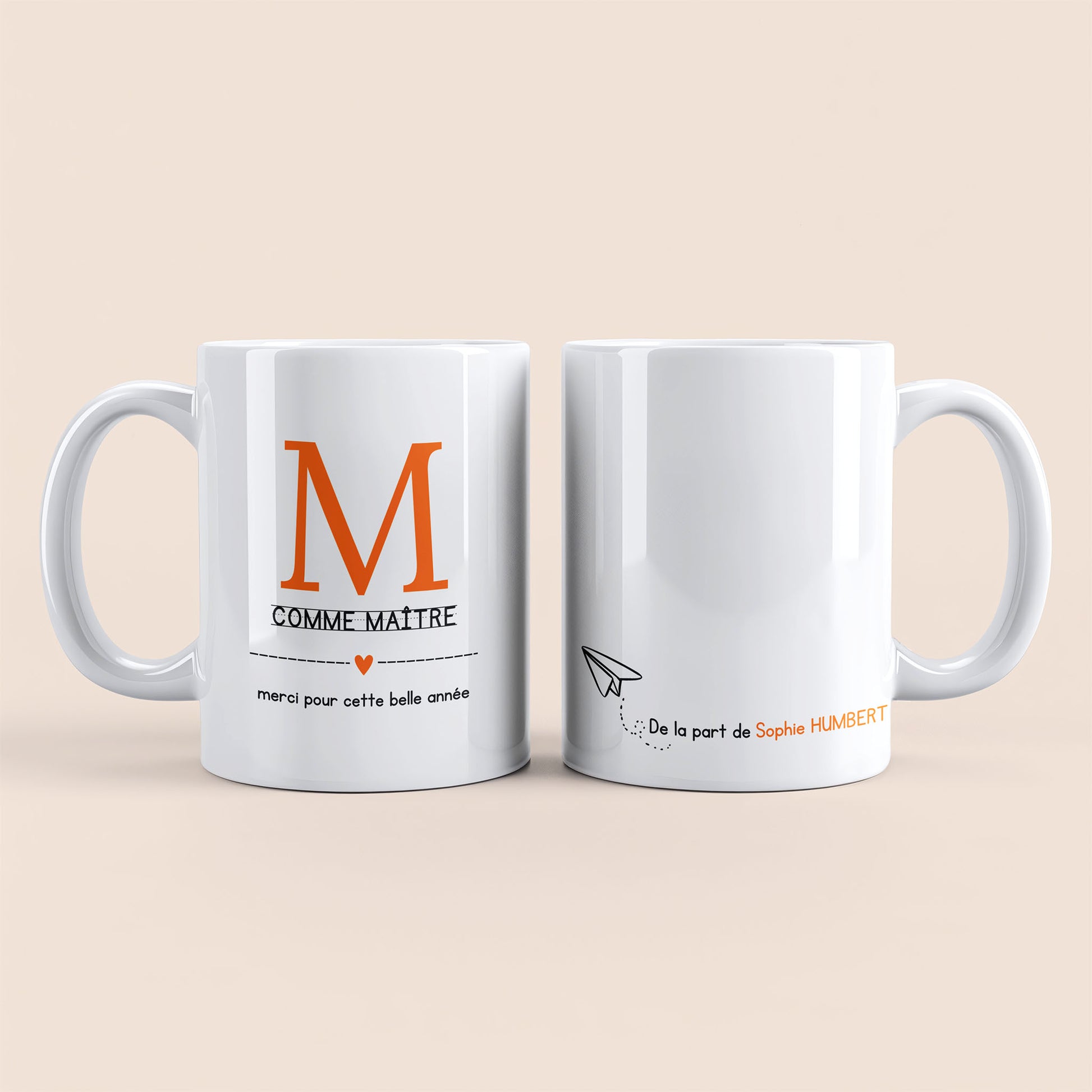 Mug blanc. Lettre M (maître) et un cœur orange plus texte à gauche. Texte personnalisé avec nom à droite.