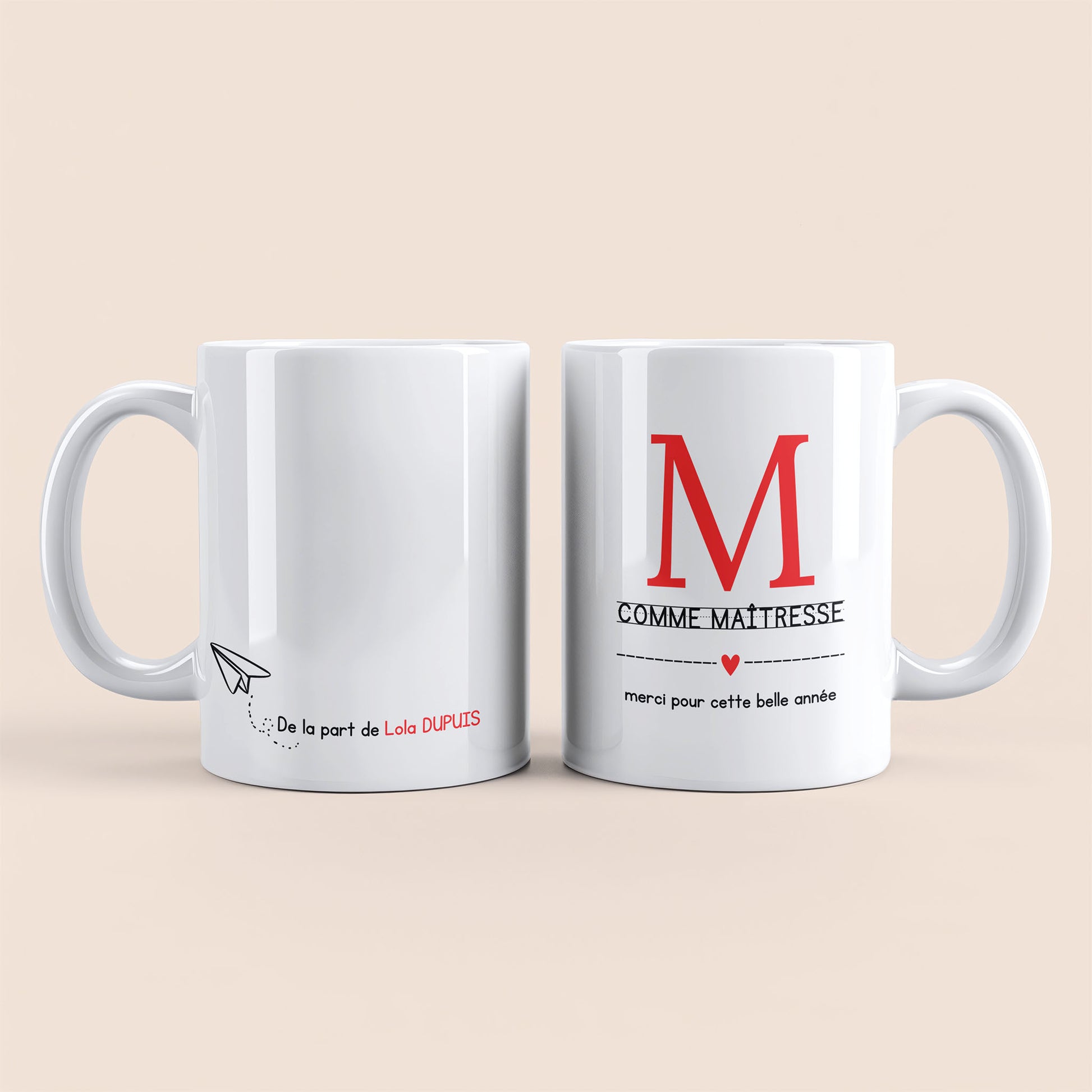 Mug blanc. Lettre M (maîtresse) et un cœur rouge plus texte à droite. Texte personnalisé avec nom à gauche.