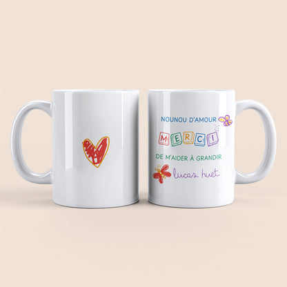 Mug blanc. Dessin cœur rouge et orange au centre à gauche. Texte "Nounou d'amour", "Merci de m'aider à grandir", " Lucas Huet" personnalisable et dessin abeille et papillon à droite.