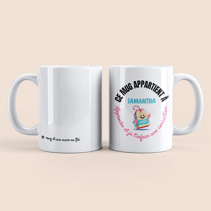Mug blanc. Texte "#mug d'une accro au thé" en bas à gauche. Texte arrondi "Ce mug appartient à prénom, approche et je te t'infuse une correction" personnalisé et un sachet de thé souriant à droite.